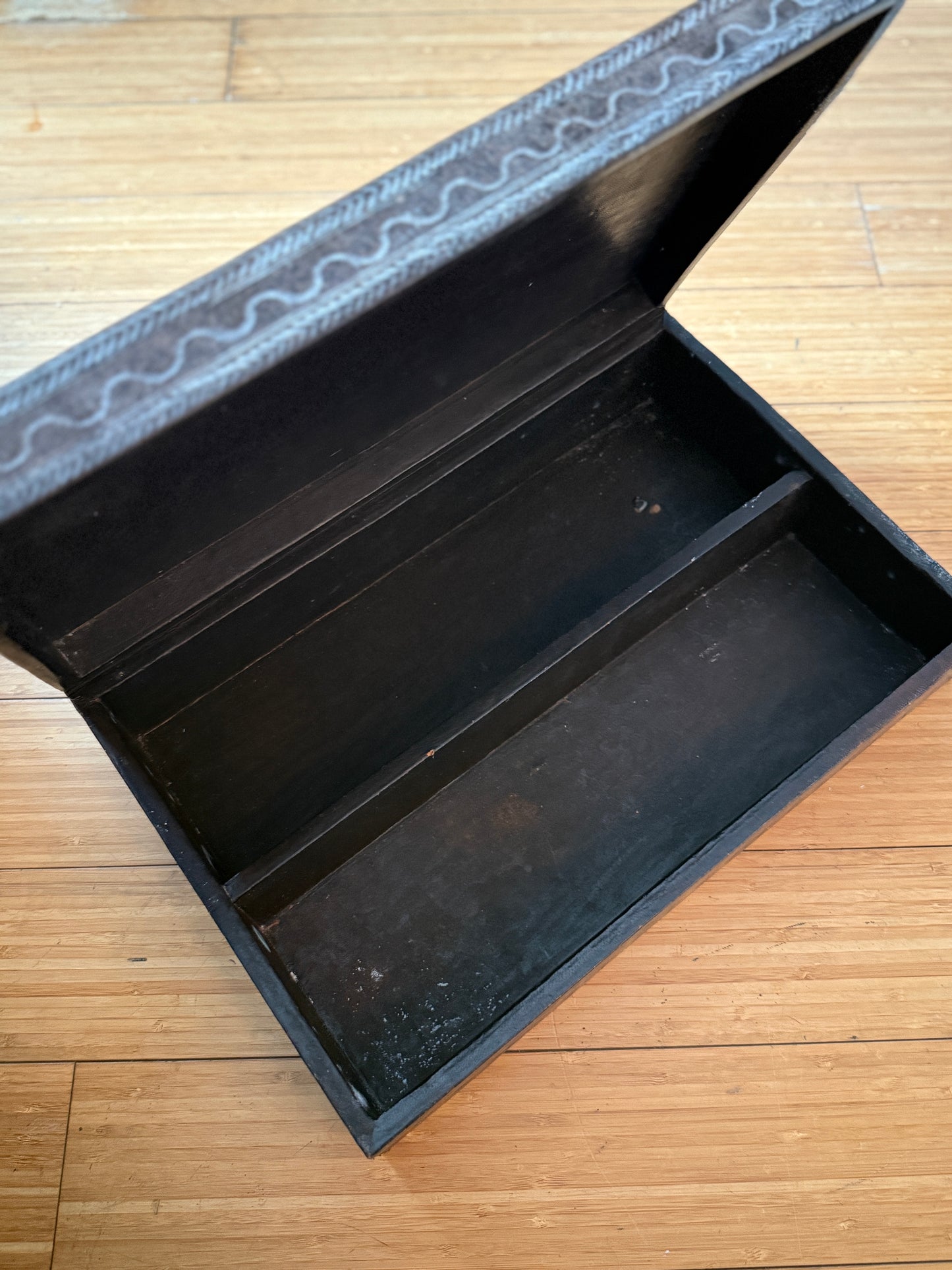Open view of leather box with intricate details and patterns